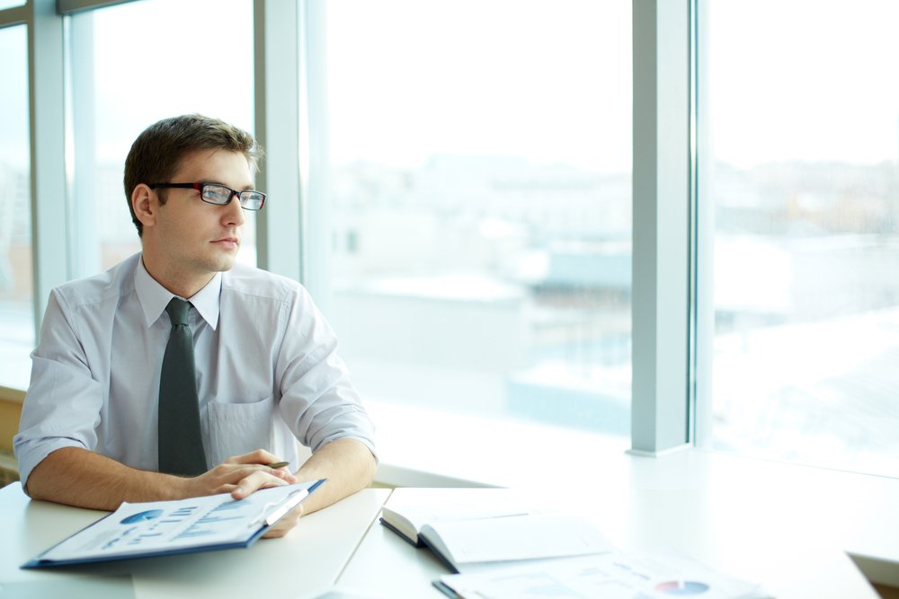 a man in the work place staring out a window